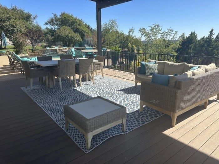 A patio with furniture arranged on a blue rug