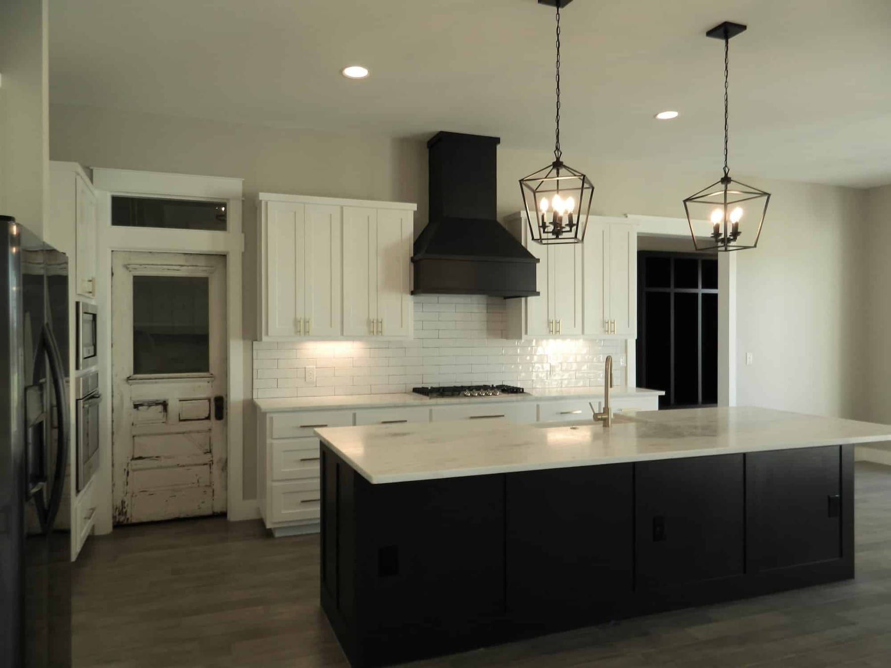 Modern kitchen design with black island in Summer Oaks Custom Home in Austin, TX