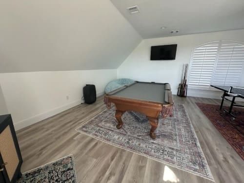 A billiard table in a room with a couch