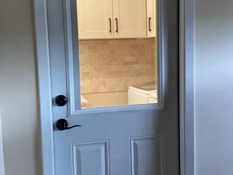 Laundry room view through door with cabinets and washer in Austin, TX home