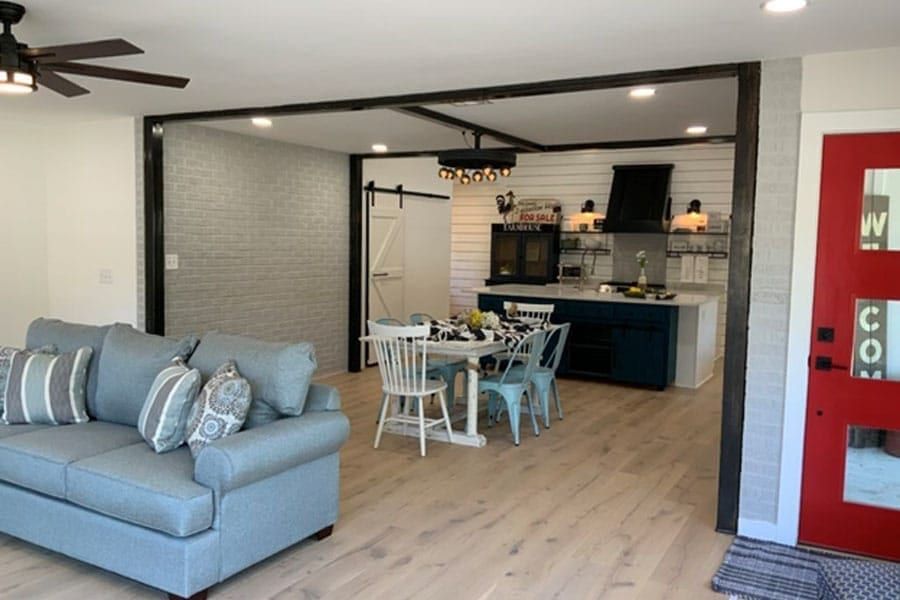 Open living and dining area with kitchen, barn door, and red entry door in Austin, TX home