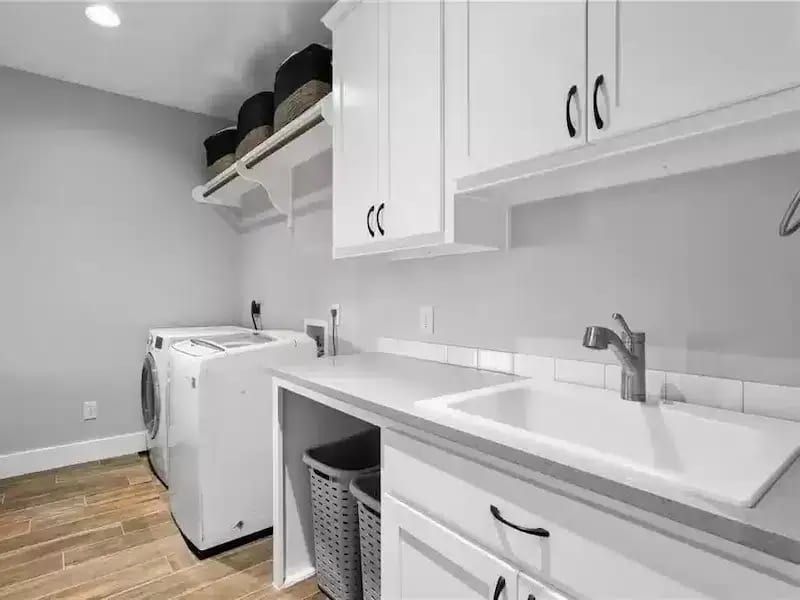 Modern laundry room with white cabinets and sink in Austin, TX