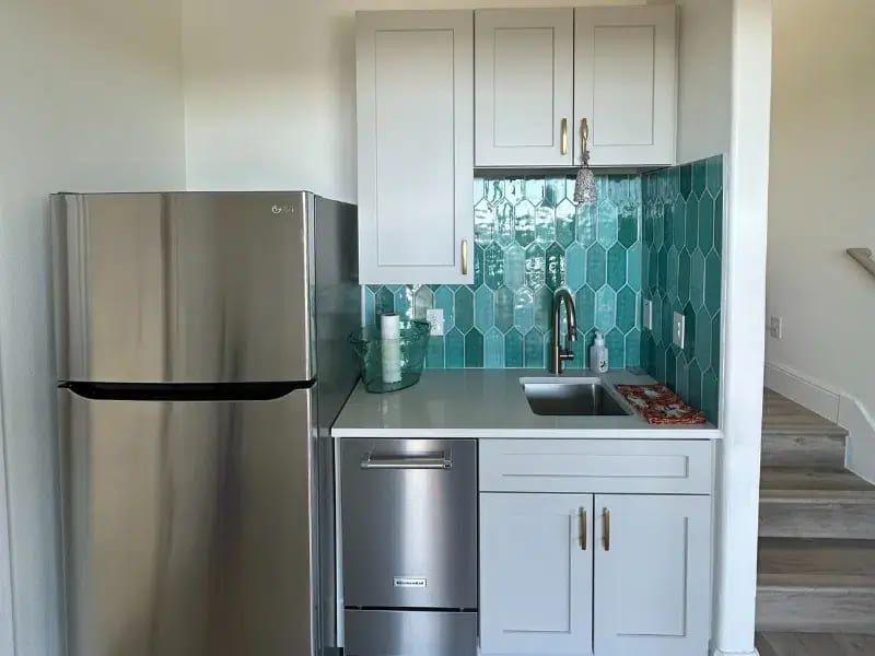 Compact kitchen space with teal backsplash in El Cielo Whole Home Remodel, Austin TX