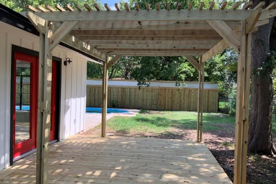 New cedar pergola over a wood deck, with the pool and privacy fence beyond