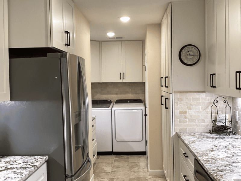 View from the kitchen through to the laundry room, with the refrigerator and pantry cabinets on the left