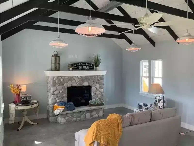 Vaulted living room with exposed beams and stone fireplace in an Austin, TX