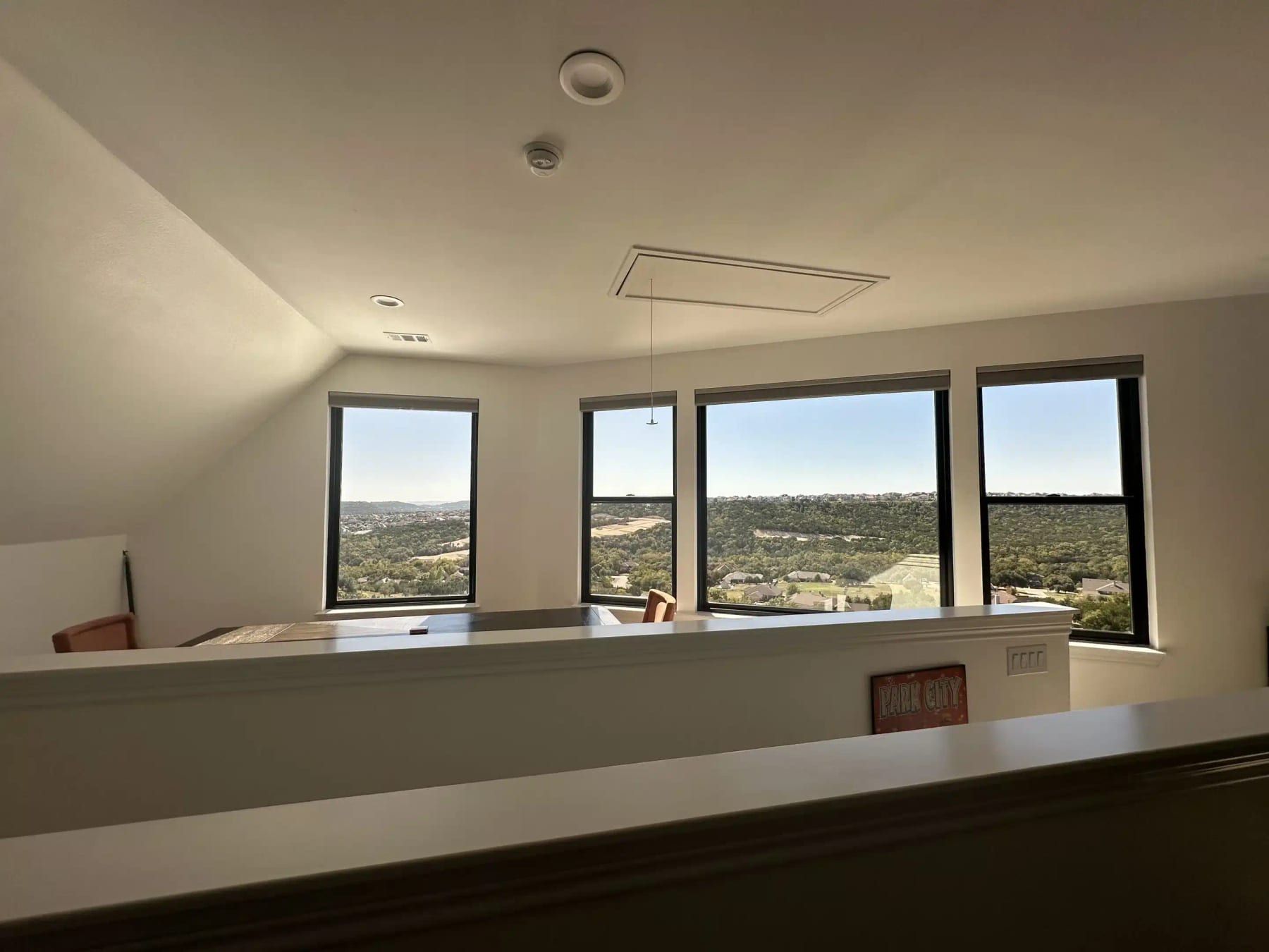 Bright upstairs living space with large windows overlooking hills in Austin, TX