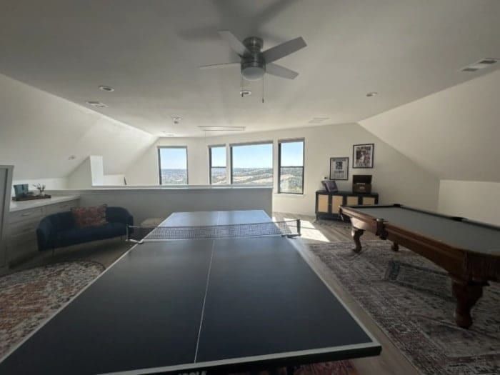 A ping pong table & a pool table are set up in a recreational room