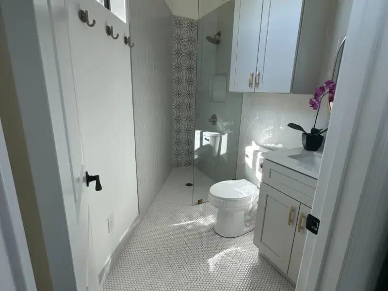 Compact bathroom with walk-in shower and patterned tile in a renovated Austin, TX