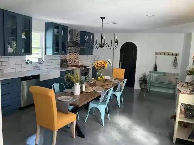 Spacious kitchen and dining area with blue cabinets, farmhouse table in Austin, TX home