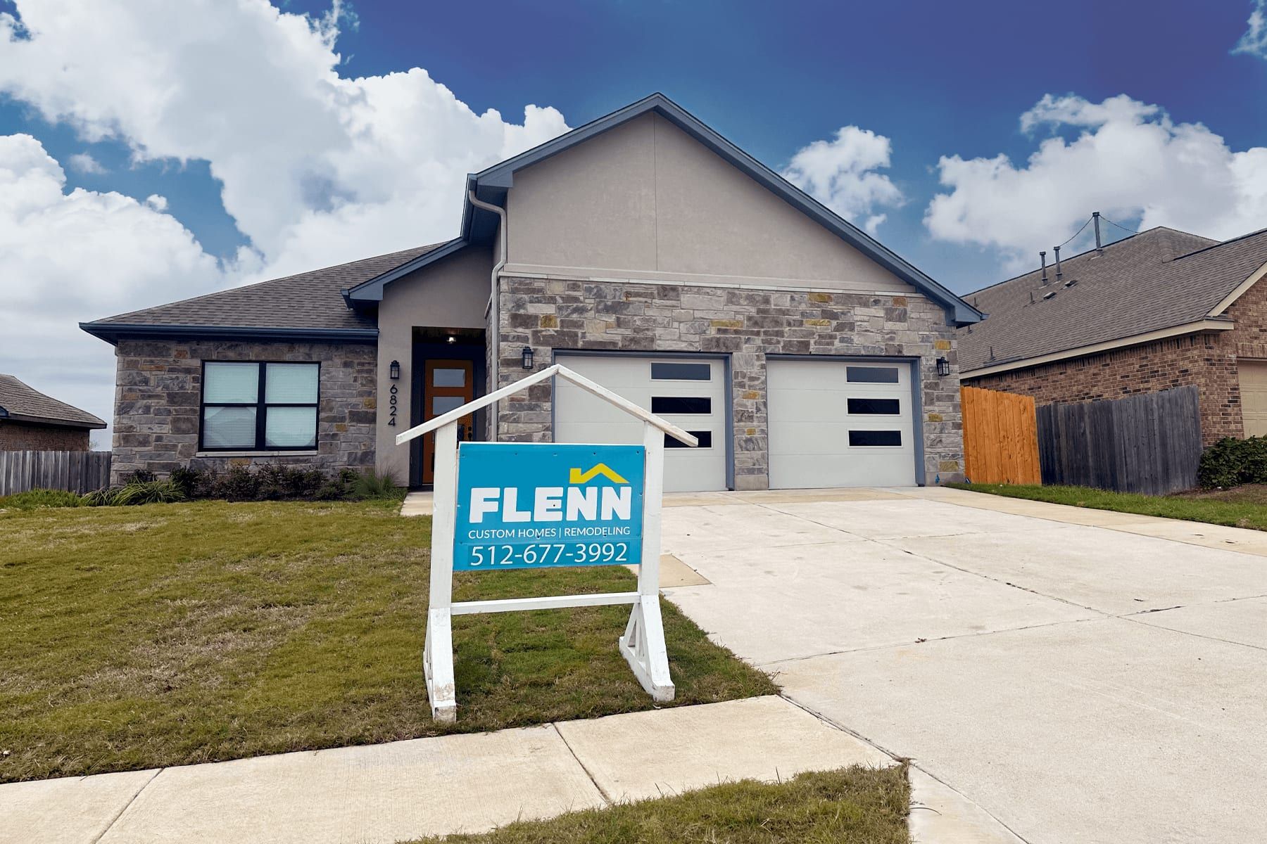 Newly completed stone and stucco custom home in Round Rock with the Flenn sign out front