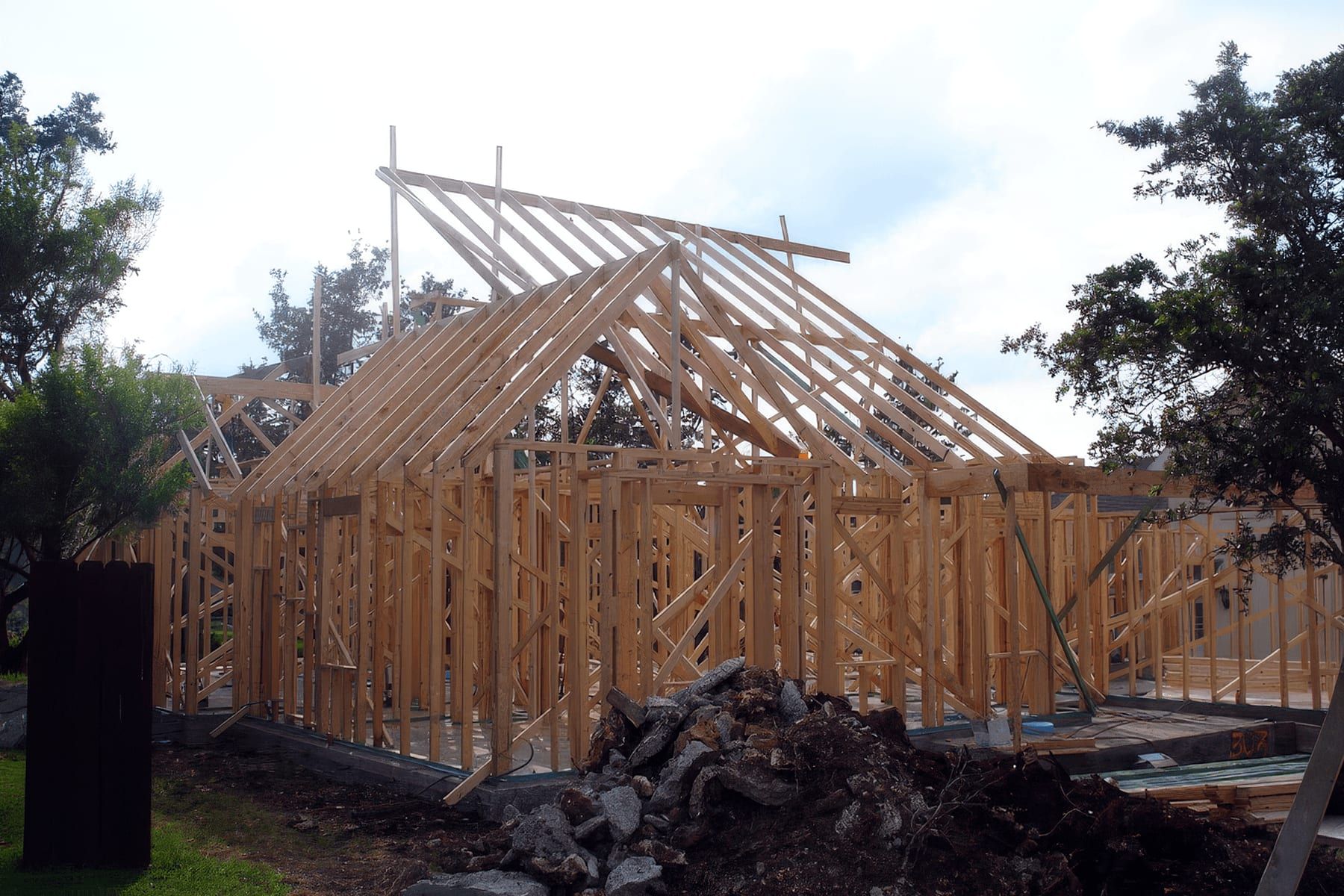 Framing underway on a custom home in Georgetown, roof trusses going up