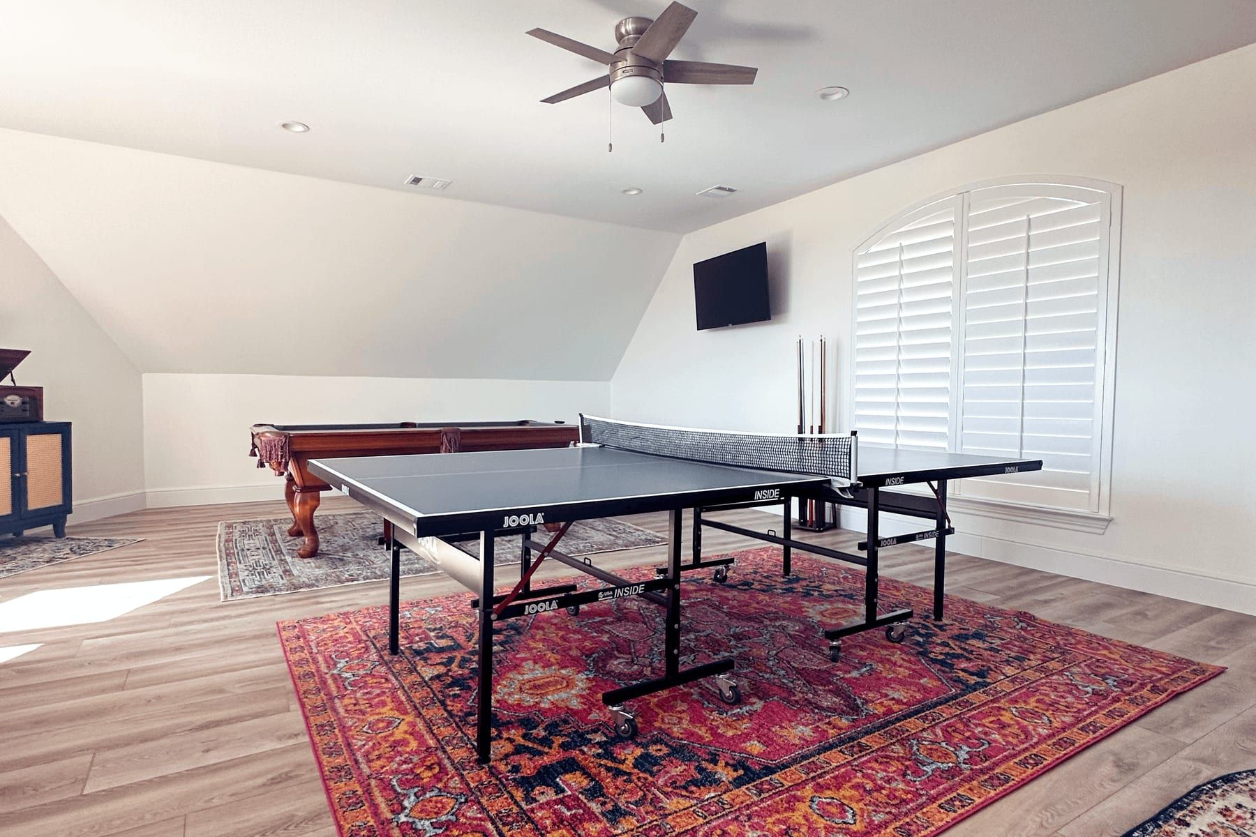 Family room addition with vaulted ceiling, plantation shutters, and a game table