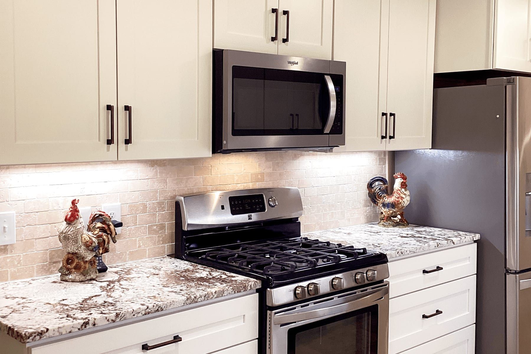 Kitchen range wall with under-cabinet lighting and granite counters in Georgetown