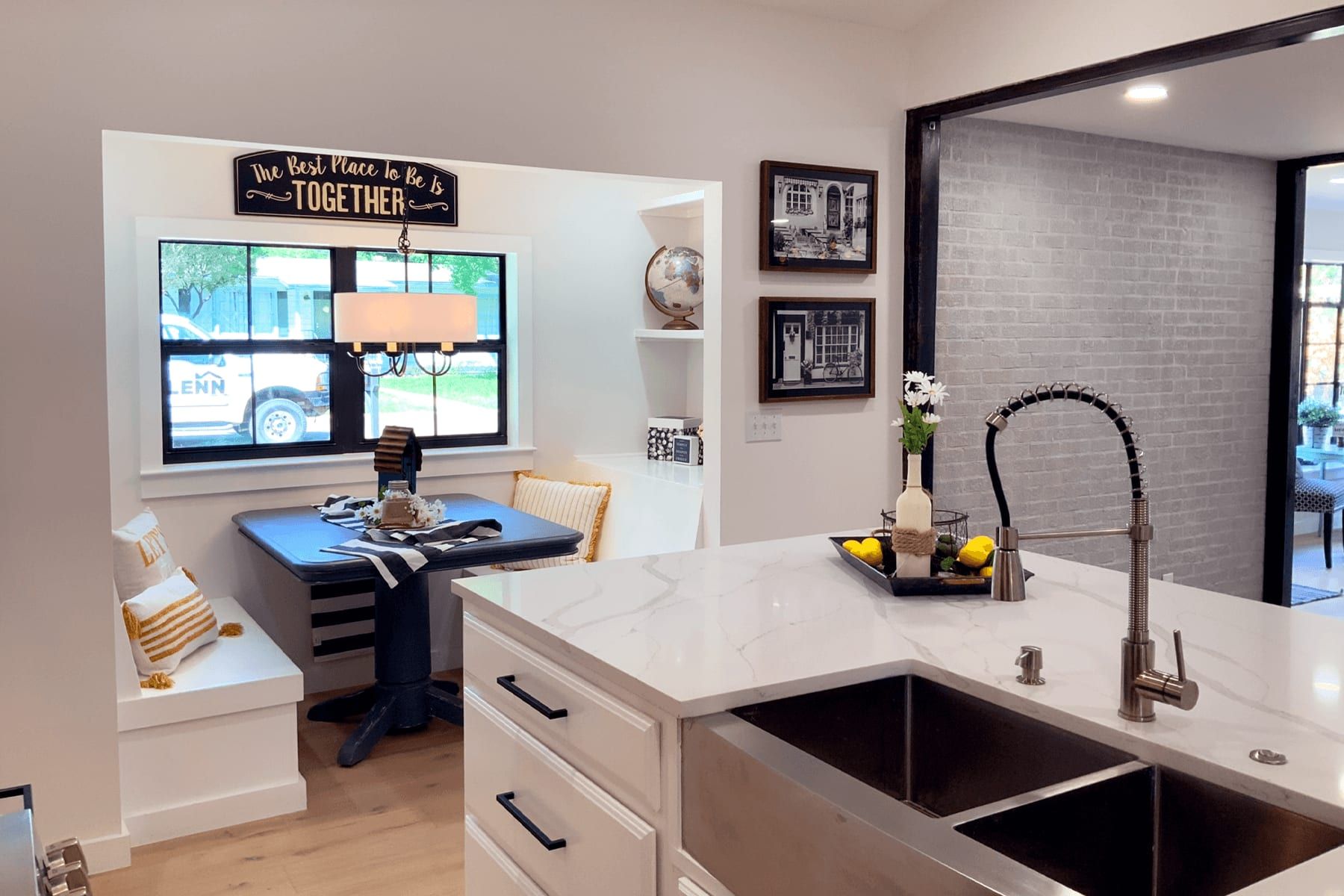 Extended living space with a kitchen island, farmhouse sink, and built-in breakfast nook