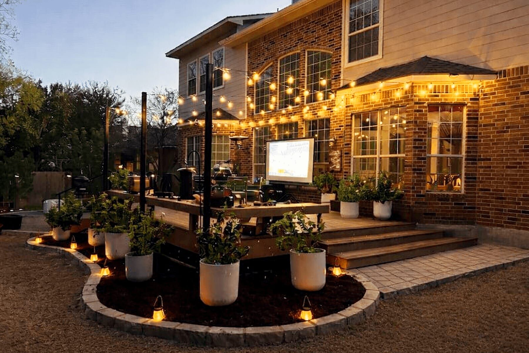 Outdoor deck in Cedar Park at dusk with string lights, planters, and a projector screen