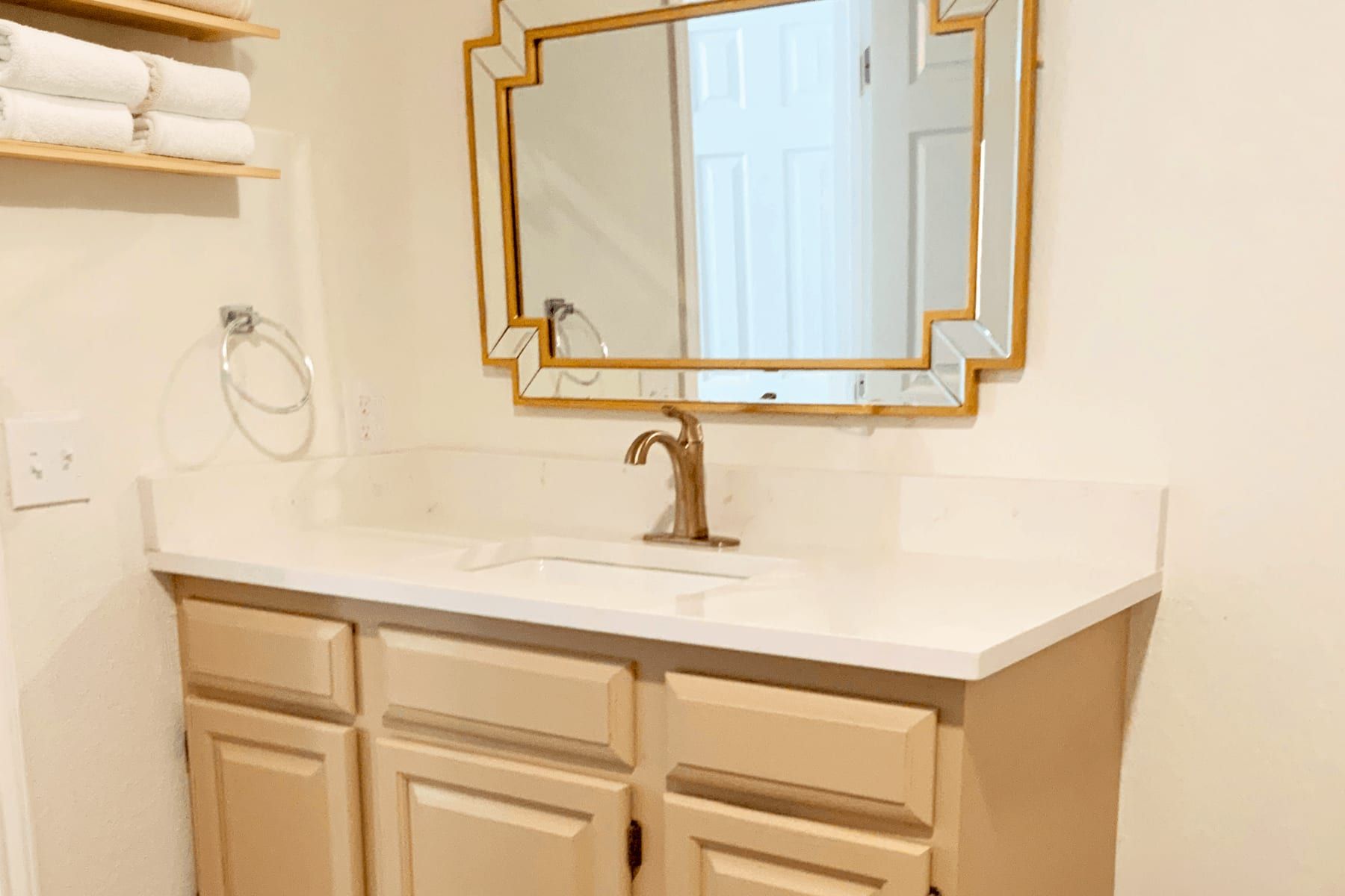 Primary bath vanity in Hudson Bend with a quartz top and brass fixtures