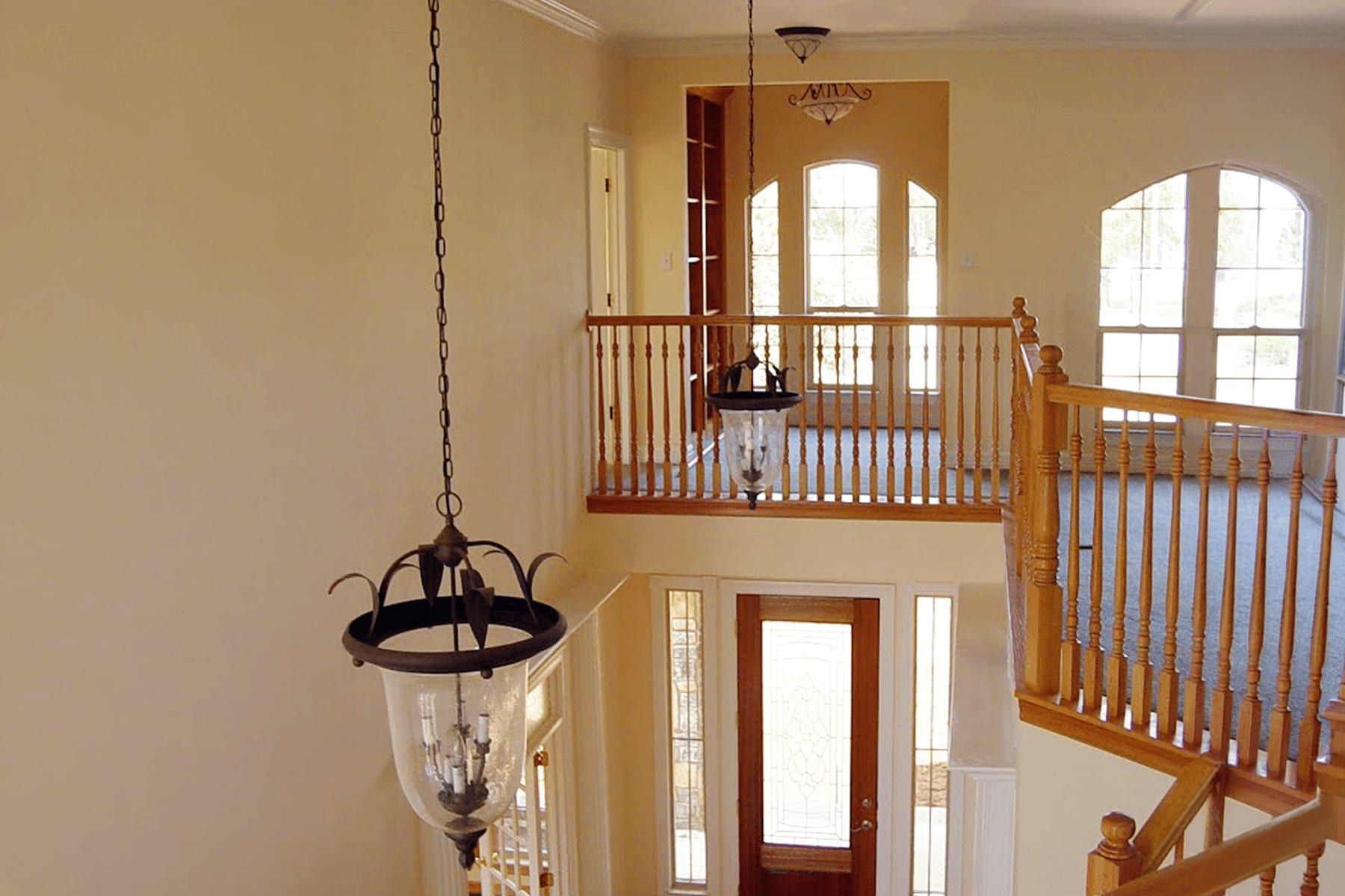 Second-story addition seen from the entry, with a landing balcony and arched windows