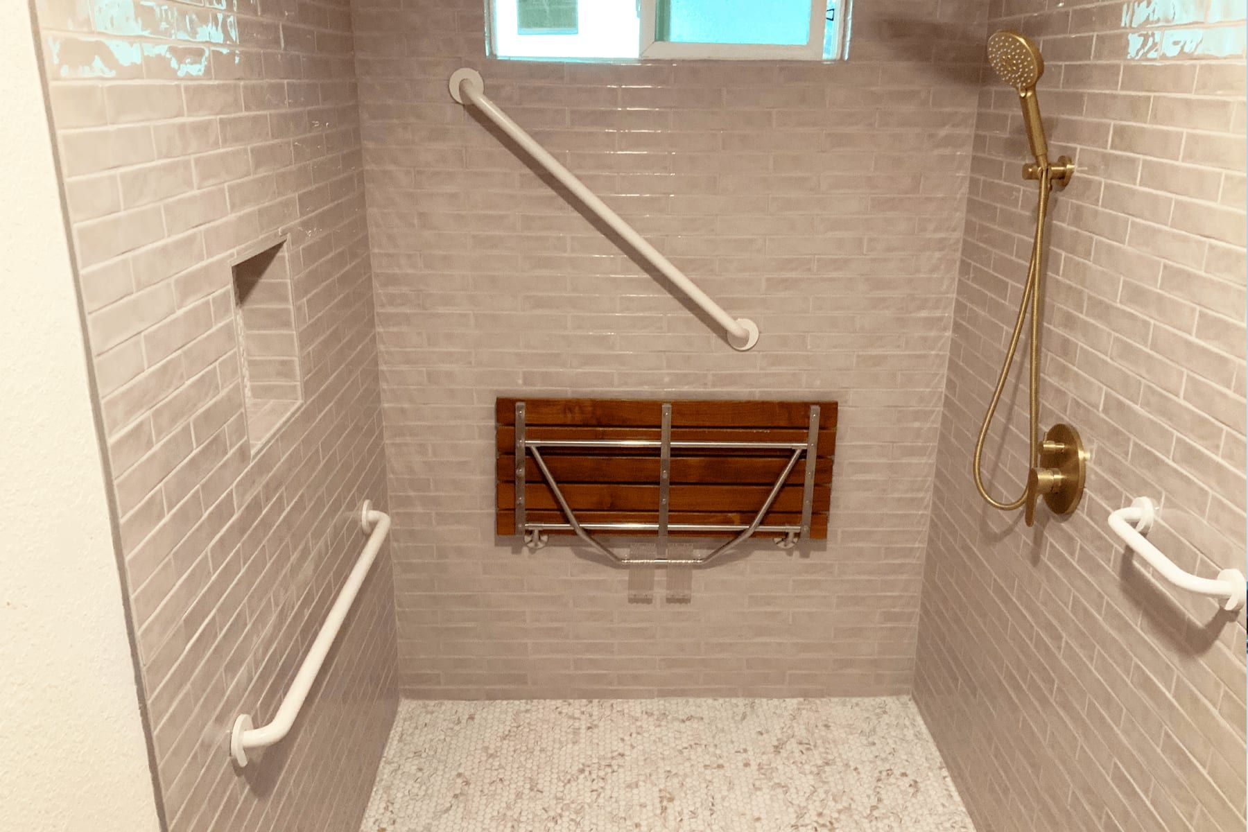 Tiled shower in Hudson Bend with grab bars, a fold-down bench, and a handheld shower