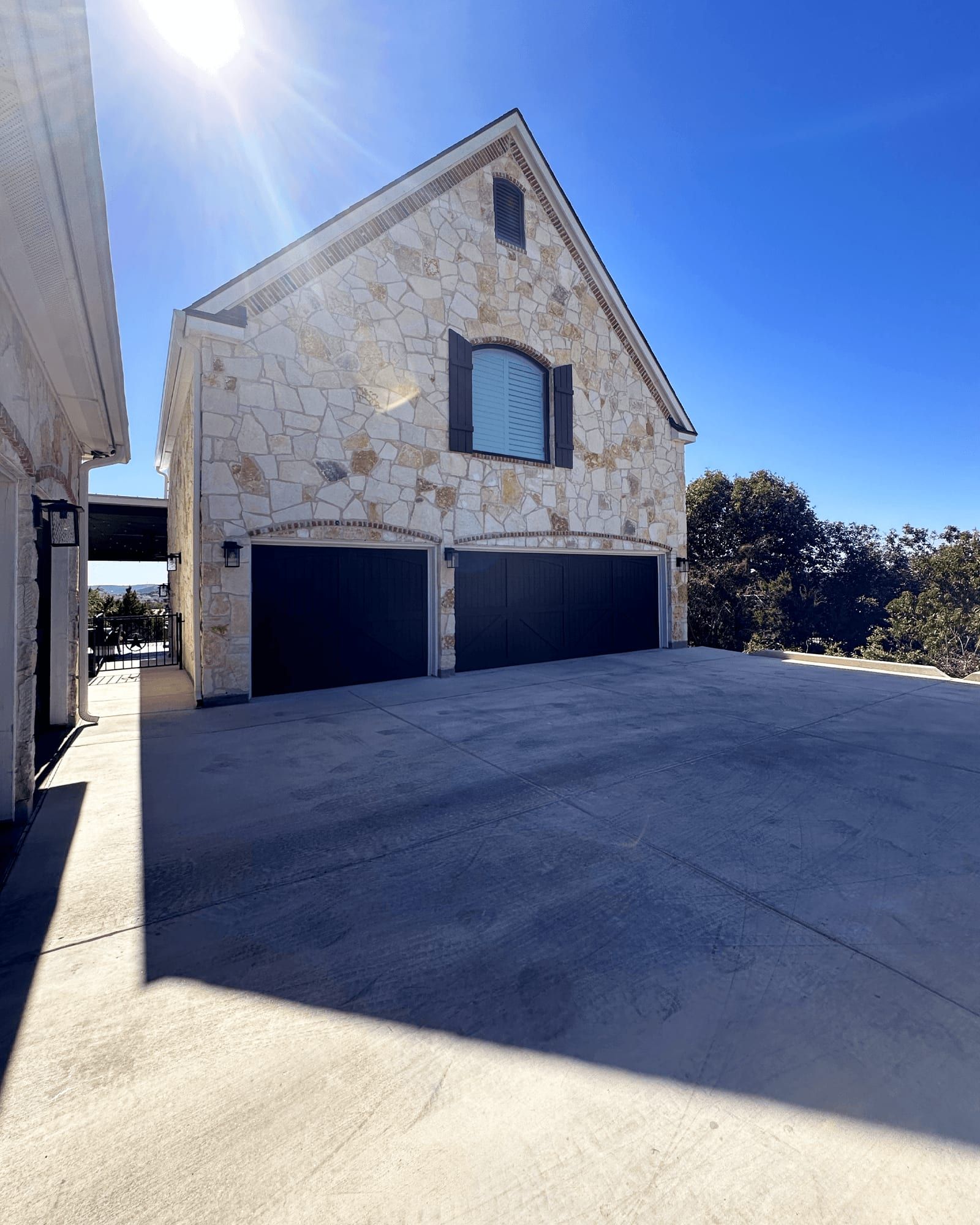 The finished custom home on the same Leander lot, with a stone exterior and two-car garage