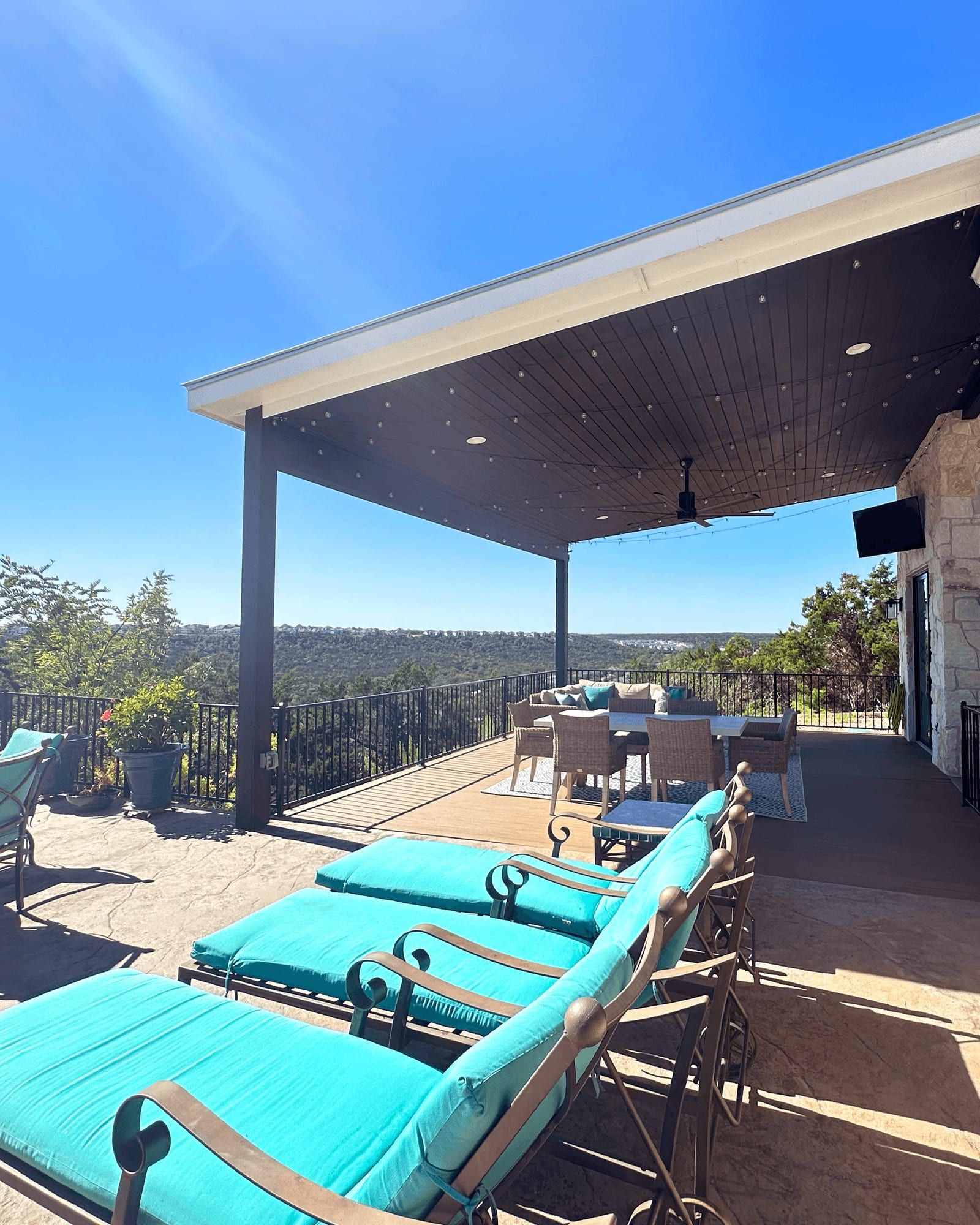 The finished covered patio addition with outdoor seating and a Hill Country view