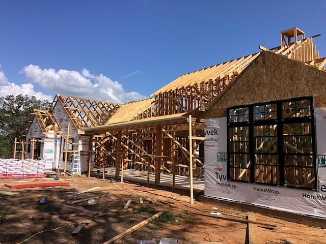 A Flenn custom home part-framed, roof trusses and house wrap up, before the exterior goes on