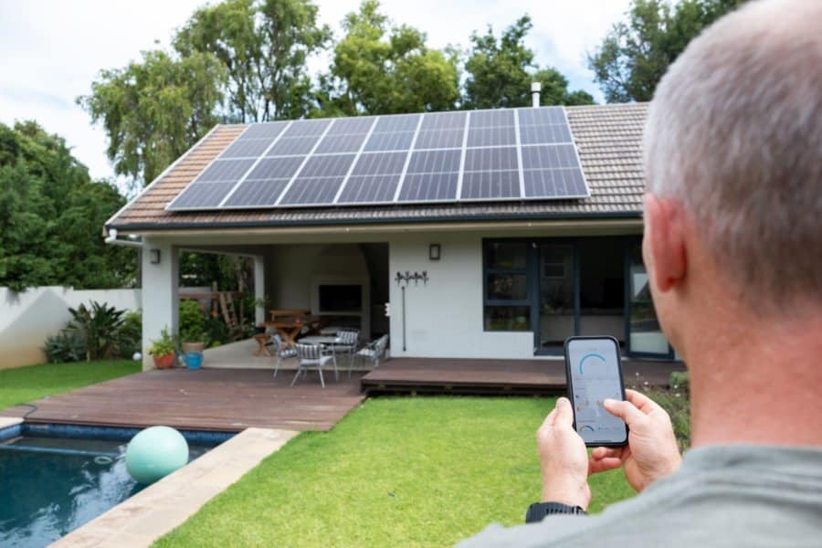 A man adjusts solar panels with a phone app on his Austin, TX home remodeled by Flenn Custom Homes and Remodels